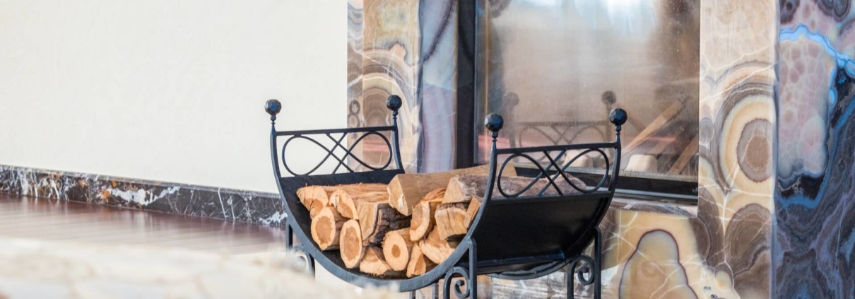 A stack of wood in front of a proper fireplace and chimney serviced by a chimney professional