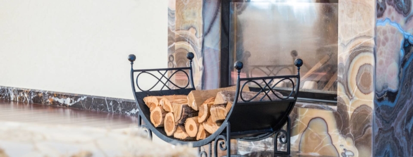 A stack of wood in front of a proper fireplace and chimney serviced by a chimney professional