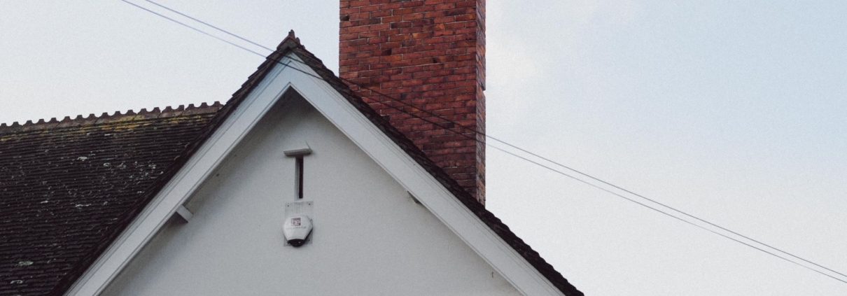 A smoking chimney on top of a residential house in northern virginia that would need chimney cleaning in different seasons.