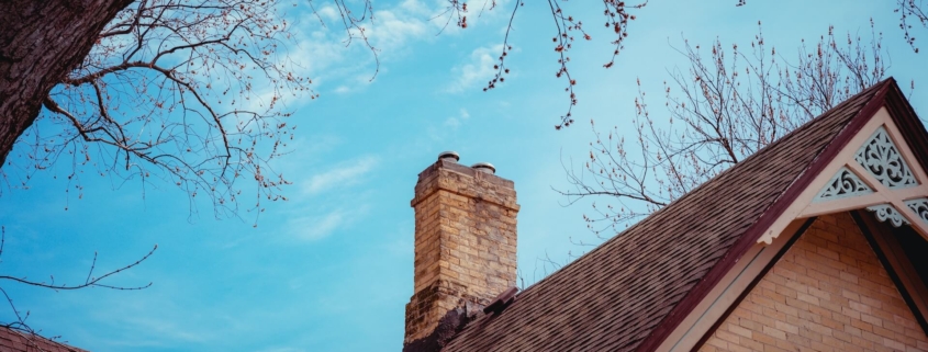 A Chimney with ciimney damage on top of a house