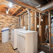 White washer and dryer in unfinished basement laundry room