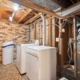 White washer and dryer in unfinished basement laundry room