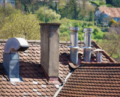 An image of a roof with different chimneys